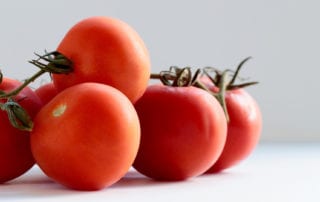 fresh Ray & Mascari tomatoes on white kitchen table